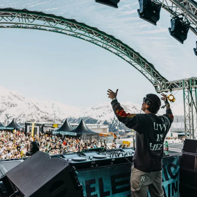 DJ am Pult mit Blick über das Festivalgelände und die Ötztaler Alpen